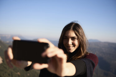 Frau nimmt Selfie im Stehen gegen den Himmel - CAVF38869