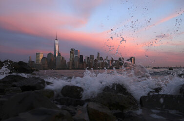 Fließender Fluss vor Stadtbild in New York in der Abenddämmerung - CAVF38895