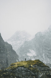 Fernansicht einer Person, die im Winter auf einem Berg steht - CAVF38901