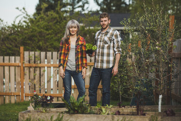 Porträt eines Paares mit Pflanzen im Hinterhof stehend - CAVF38933
