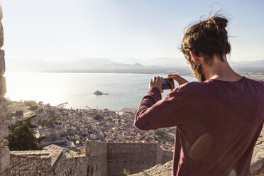 Greece, Peloponnese, Argolis, Nauplia, Argolic Gulf, man photographing view to Bourtzi Castle - MAMF00025