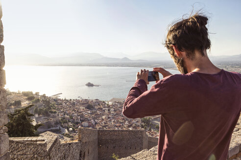 Griechenland, Peloponnes, Argolis, Nauplia, Argolischer Golf, Mann fotografiert Blick auf die Burg Bourtzi - MAMF00025