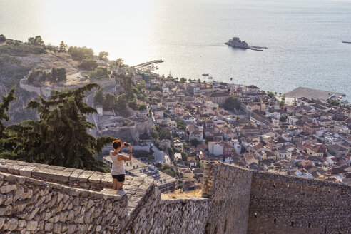 Griechenland, Peloponnes, Argolis, Nauplia, Argolischer Golf, Frau fotografiert Blick auf die Burg Bourtzi - MAMF00027