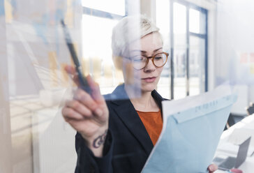 Businesswoman working on document in office - UUF13328