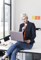 Businesswoman working on laptop in office - UUF13337