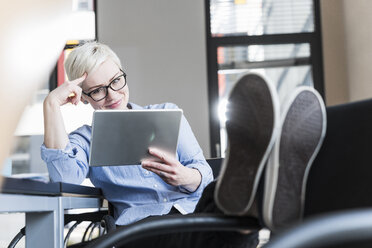 Lächelnde Frau mit Tablet im Büro - UUF13355