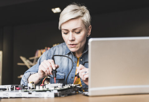 Frau arbeitet an Computerausrüstung - UUF13393