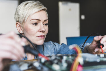 Woman working on computer equipment - UUF13396