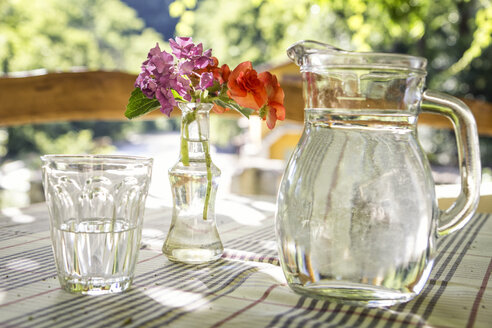 Glasgefäß und Glas Wasser auf dem Tisch - MAMF00046