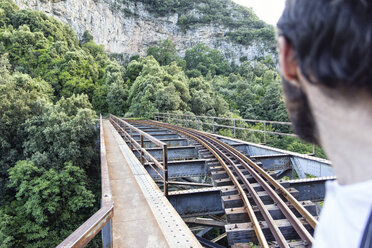 Greece, Pilion, Milies, man looking at rails of Narrow Gauge Railway - MAMF00051