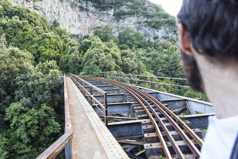 Griechenland, Pilion, Milies, Mann betrachtet die Schienen der Schmalspurbahn - MAMF00051