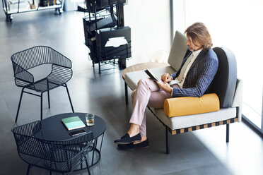 Hohe Winkel Ansicht der Geschäftsmann mit Tablet-Computer beim Sitzen auf dem Sofa im Büro - CAVF39095
