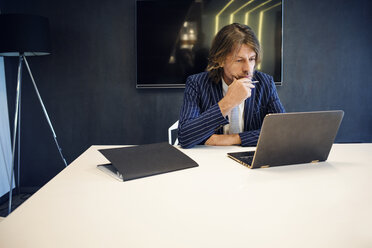 Mature businessman using laptop in office - CAVF39096