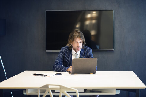 Älterer Geschäftsmann mit Laptop im Büro - CAVF39099