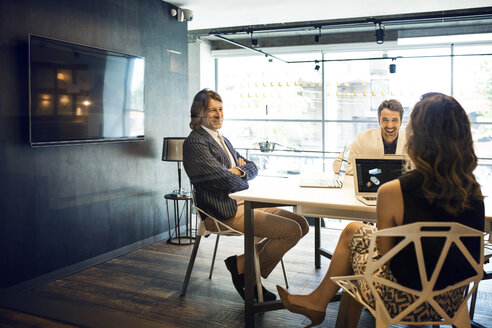 Geschäftsleute, die während einer Sitzung im Büro lächeln - CAVF39102