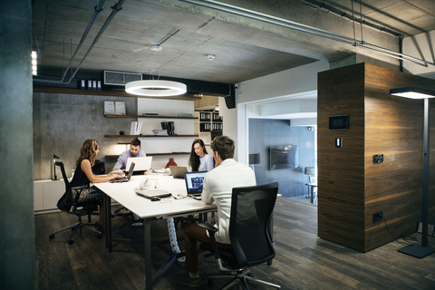 Geschäftsleute benutzen Laptops bei der Arbeit im Büro, lizenzfreies Stockfoto