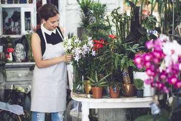 Blumenhändlerin arrangiert Blumen im Geschäft - CAVF39145