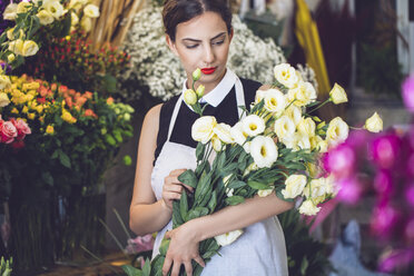Blumenhändlerin hält Blumenstrauß im Geschäft - CAVF39146