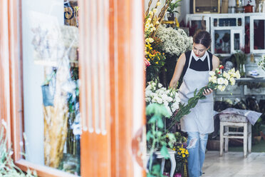 Inhaberin arrangiert Blumenstrauß im Geschäft - CAVF39155