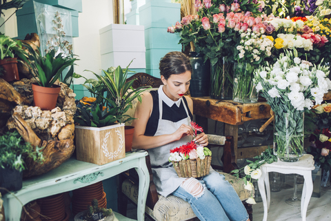Florist arrangiert Blumen im Topf im Geschäft, lizenzfreies Stockfoto