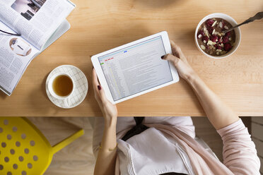 High angle view of woman using tablet computer at table - CAVF39192