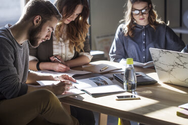 College students studying at table in classroom - CAVF39236