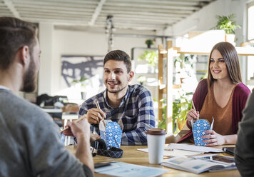 Freunde, die am Tisch im Klassenzimmer sitzen und essen - CAVF39299