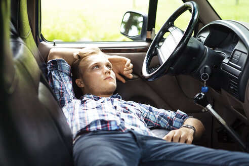 Mann schaut weg, während er sich in einem Pick-up entspannt - CAVF39393