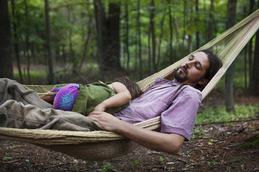 Vater und Tochter schlafen in einer Hängematte im Wald - CAVF39418
