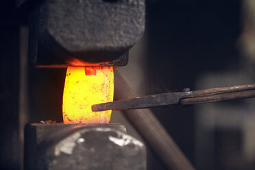 Nahaufnahme von rotem, heißem Metall, das von einer Zange in der Metallindustrie gehalten wird - CAVF39427