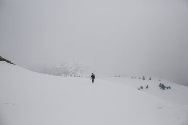 Österreich, Kitzbühel, Frau geht in verschneiter Landschaft spazieren - GUSF00626