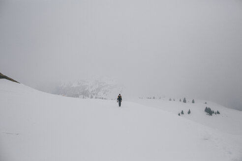 Österreich, Kitzbühel, Frau geht in verschneiter Landschaft spazieren - GUSF00626