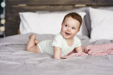 Happy baby lying on bed at home - ABIF00317