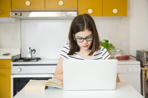 Mädchen benutzt Laptop in der Küche - LVF06866