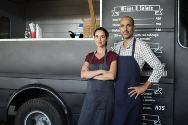 Portrait of confident owners standing against food truck - CAVF39493