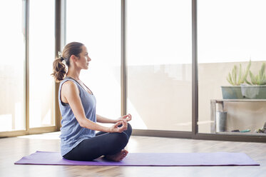 Seitenansicht einer Frau, die zu Hause Yoga praktiziert - CAVF39524
