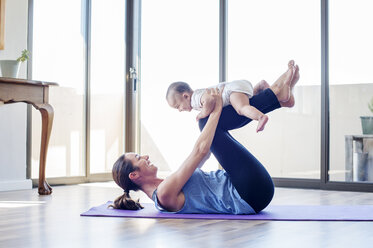 Side view of woman playing with son at home - CAVF39527