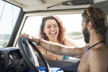Glückliche Frau im Gespräch mit einem männlichen Freund, der in einem Geländewagen sitzt - CAVF39551
