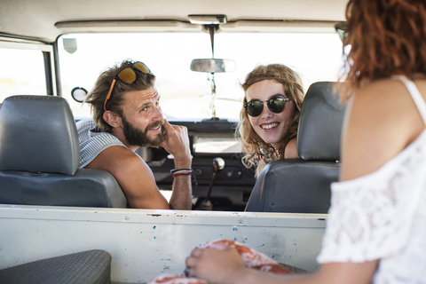 Glückliche Freunde unterhalten sich im Geländewagen, lizenzfreies Stockfoto
