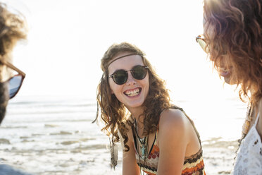 Friends enjoying at beach against clear sky during sunny day - CAVF39582