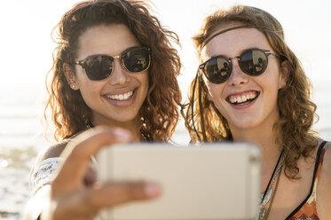 Glückliche Freundinnen nehmen Selfie am Strand - CAVF39588