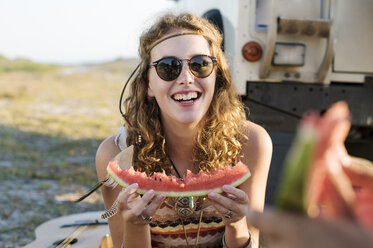 Glückliche Frau isst Wassermelone am Strand - CAVF39592