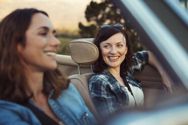 Happy female friends traveling in convertible car - CAVF39649