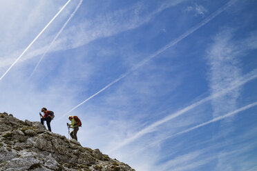 Niedriger Blickwinkel von Wanderern Bergsteigen gegen Himmel - CAVF39693