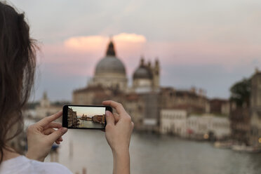 Cropped image of woman photographing Santa Maria della Salute during sunset - CAVF39700