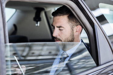 Businessman using smart phone in car - CAVF39721