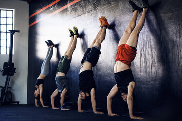 Determined athletes doing handstands in gym - CAVF39764