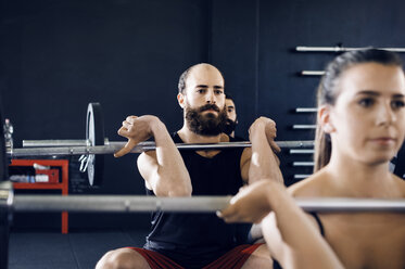 Entschlossene Sportler heben Hanteln im Fitnessstudio - CAVF39775