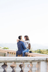 Romantisches Paar umarmt sich auf der Terrasse gegen den klaren Himmel - CAVF39822