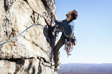 Man rock climbing against clear sky - CAVF39921